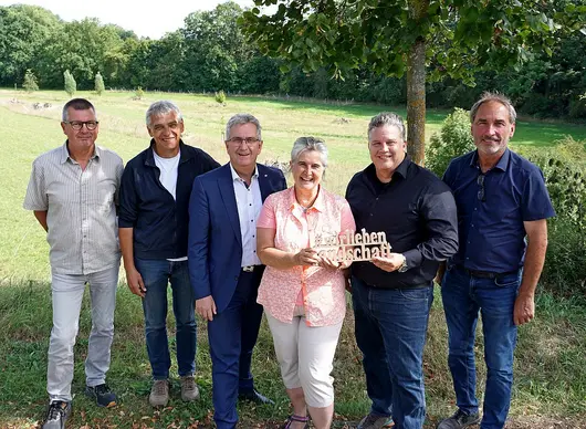 Fotos mit sechs Personen vor einer Wiese